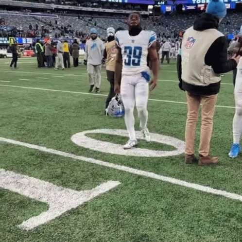 a football player with the number 39 on his jersey walks on the field