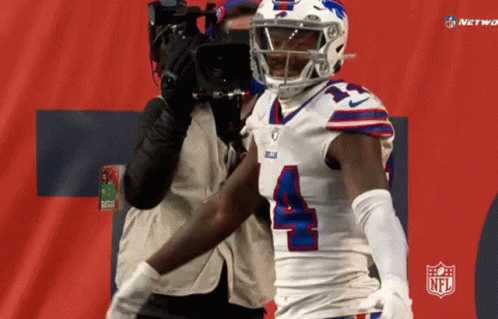 A Football Player With The Number 4 On His Jersey Stands In Front Of A Camera GIF