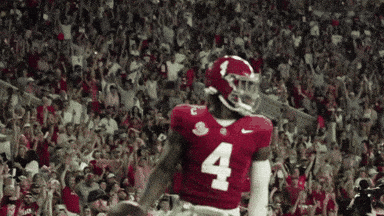 a football player with the number 4 on his jersey stands in front of a crowd