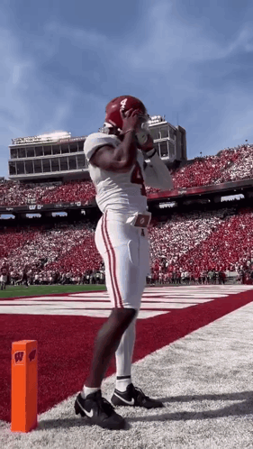 a football player with the number 4 on his jersey stands on the field