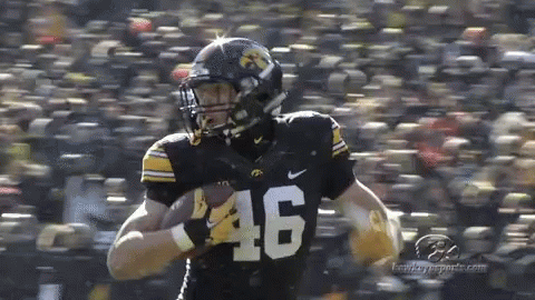 A Football Player With The Number 46 On His Jersey Is Running With The Ball . GIF