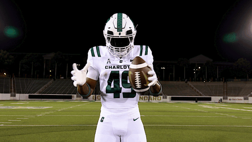 a football player with the number 49 on his jersey holds a football