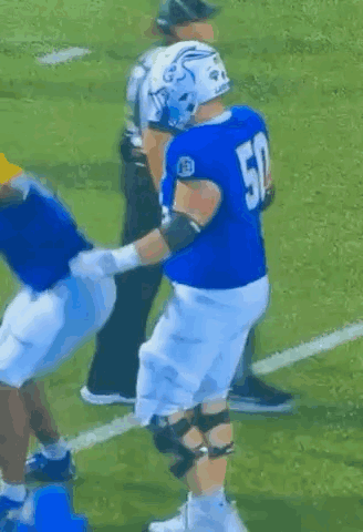 a football player with the number 50 on his jersey is being tackled by another player