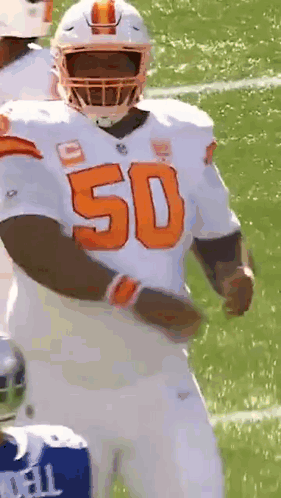 A Football Player With The Number 50 On His Jersey Is Standing On The Field . GIF