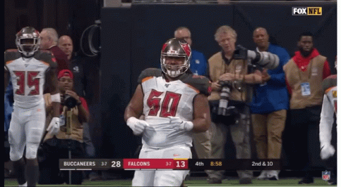 A Football Player With The Number 50 On His Jersey Stands On The Field GIF