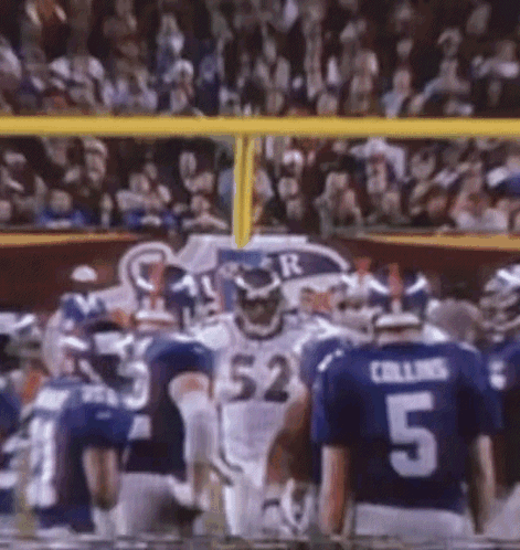 A Football Player With The Number 52 On His Jersey Stands In Front Of A Crowd GIF