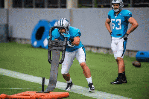 A Football Player With The Number 53 On His Jersey Is Being Pushed By A Sled GIF