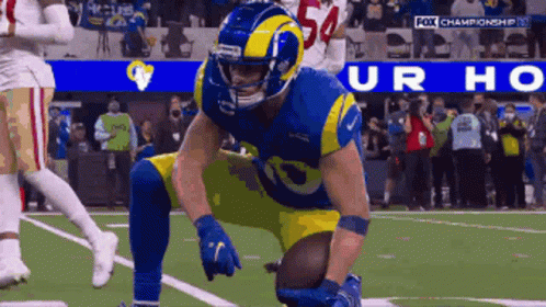 a football player with the number 54 on his helmet kneeling on the field