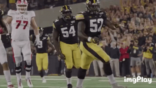 A Football Player With The Number 54 On His Jersey Is Running With The Ball GIF