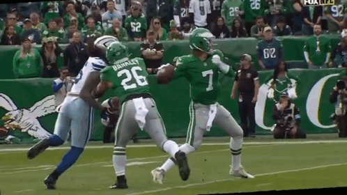 A Football Player With The Number 7 On His Jersey Is Being Tackled By Another Player GIF
