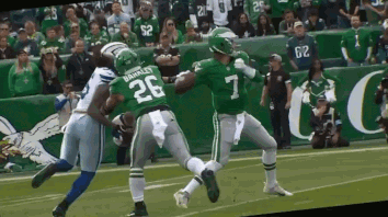 A Football Player With The Number 7 On His Jersey Is Being Tackled By Another Player GIF
