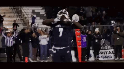 a football player with the number 7 on his jersey stands in front of a crowd