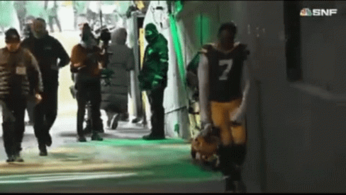 a football player with the number 7 on his jersey walks through a tunnel
