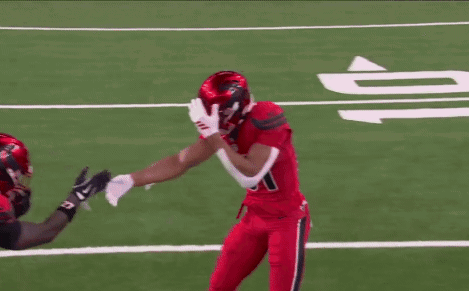 A Football Player With The Number 70 On His Jersey Hugs Another Player GIF