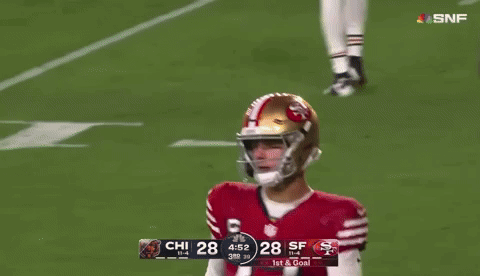 A Football Player With The Number 77 On His Jersey Stands Next To A Player With The Number 14 On His Jersey GIF