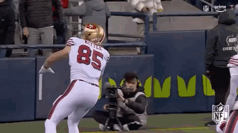 a football player with the number 85 on his back is standing on a field .