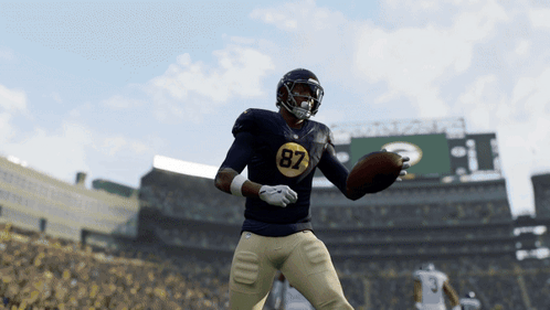 a football player with the number 87 on his jersey is throwing a ball