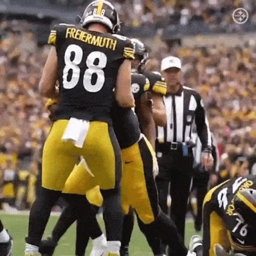 A Football Player With The Number 88 On His Jersey Is Being Tackled By Another Player . GIF