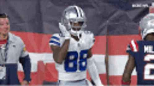 A Football Player With The Number 88 On His Jersey Stands In Front Of A Flag . GIF