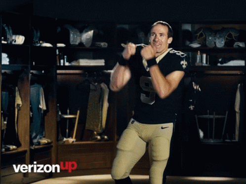 A Football Player With The Number 9 On His Jersey Stands In A Locker Room GIF