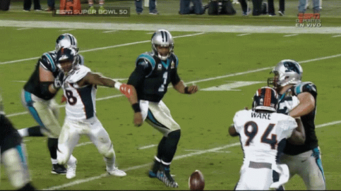 A Football Player With The Number 94 On His Jersey Is Being Tackled GIF