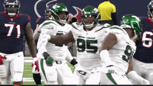 A Football Player With The Number 95 On His Jersey Is Being Hugged By His Teammates GIF