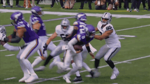 A Football Player With The Number 98 On His Jersey Is Being Tackled By A Vikings Player GIF