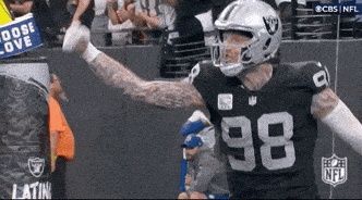 A Football Player With The Number 98 On His Jersey Stands In Front Of A Crowd GIF