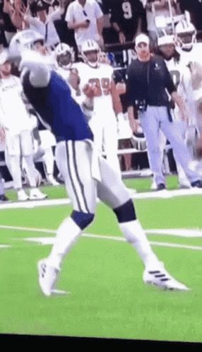 A Football Player With The Number 99 On His Jersey Is Running On The Field GIF