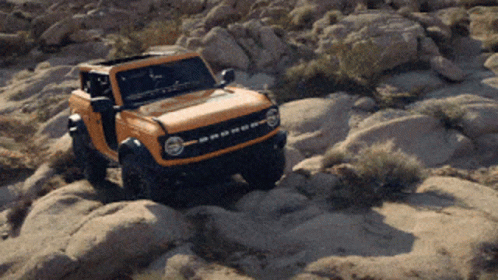 A Ford Bronco Is Driving On A Rocky Road GIF