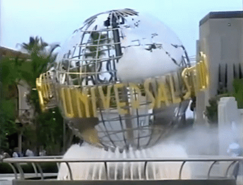 A Fountain In Front Of A Large Globe That Says Universal GIF