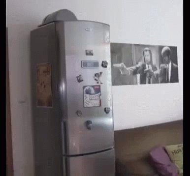 A Fridge With A Picture Of Pulp Fiction On The Wall Behind It GIF
