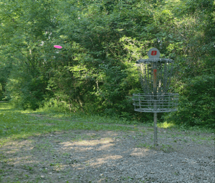 a frisbee is being thrown into a basket that has the letter b on it