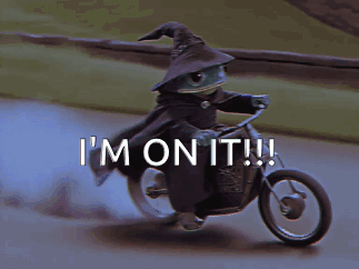 a frog wearing a witch hat is riding a motorcycle and says i 'm on it !