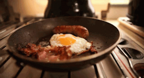 A Frying Pan Filled With Eggs Bacon And Sausage GIF