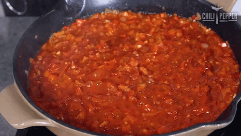 A Frying Pan Filled With Tomato Sauce With The Words Chili Pepper On The Bottom GIF