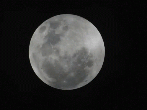 A Full Moon Is Visible In The Dark Sky GIF