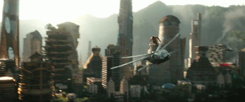 A Futuristic City With A Helicopter Flying Overhead GIF