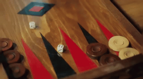 A Game Of Backgammon Is Being Played On A Wooden Board . GIF