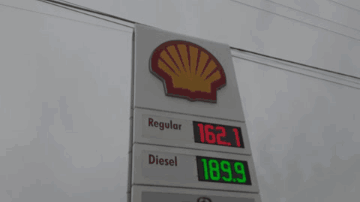 A Gas Station With A Sign That Says Regular Diesel And Bmo On It GIF