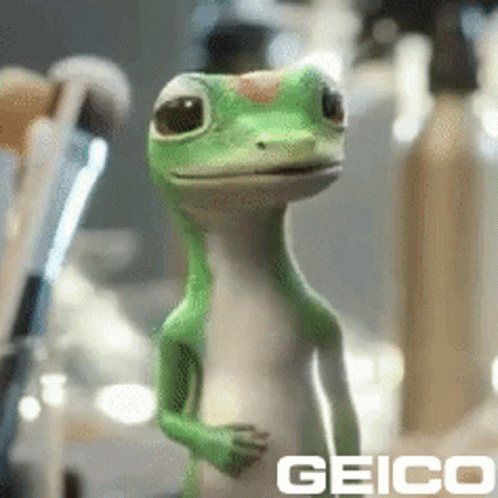 A Geico Lizard Is Standing In Front Of A Mirror GIF