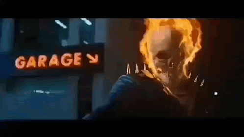 A Ghost Rider Is Riding A Motorcycle In Front Of A Garage . GIF
