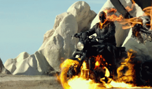 A Ghost Rider Is Riding A Motorcycle In The Desert GIF
