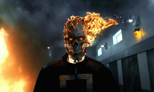 A Ghost Rider With Flames Coming Out Of His Head Is Standing In Front Of A Building With A Sign That Says Exit GIF