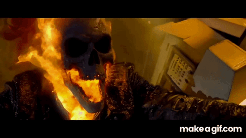 A Ghost Rider With Flames Coming Out Of His Mouth Is Standing Next To A Box GIF