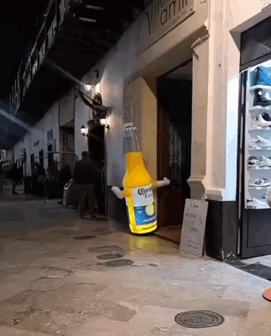 A Giant Bottle Of Corona Beer Is Sitting Outside Of A Store GIF
