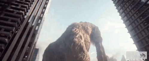 A Giant Elephant Is Standing In The Middle Of A City Looking Up At A Skyscraper .. GIF