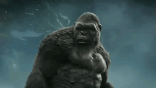 a giant gorilla is standing in the water with his arms outstretched .