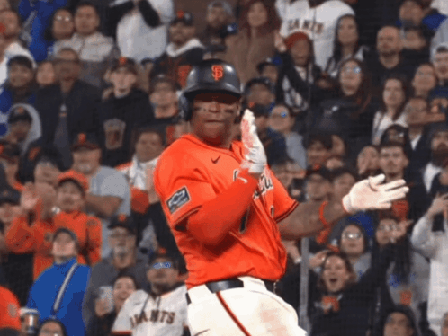A Giants Baseball Player Stands In Front Of A Crowd Holding His Bat GIF