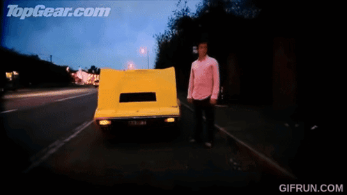 A Gif From Topgear.com Shows A Yellow Car Driving Down The Road GIF